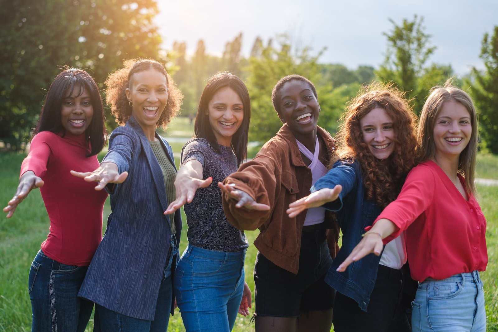 Group of empowered women celebrating together at sunset outdoors in the park